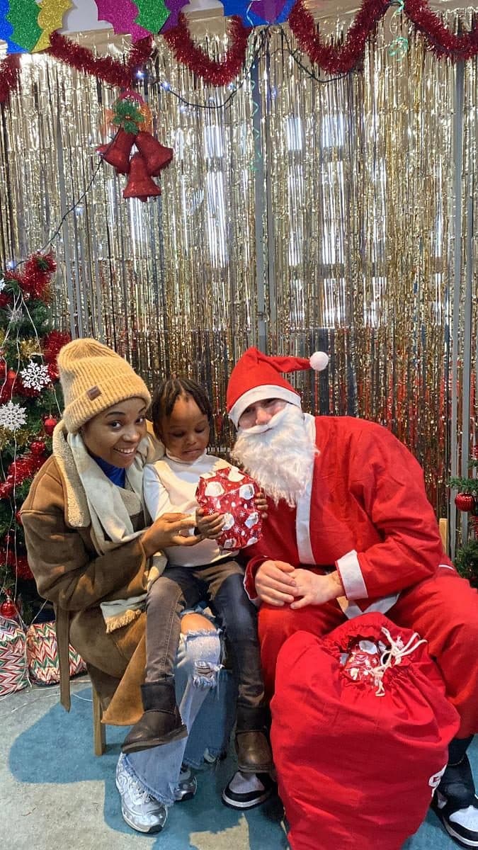 Blossoming Minds Daycare children with a practitioner at a holiday photo backdrop